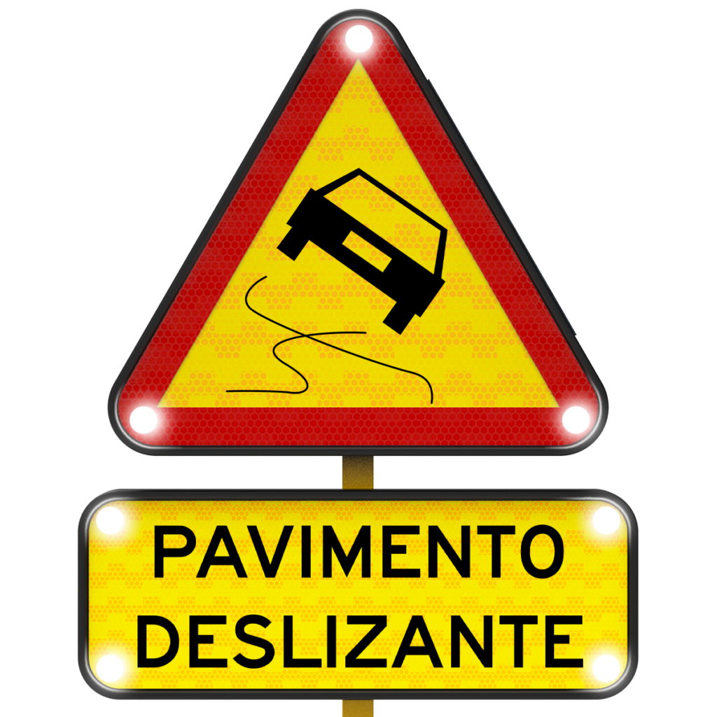 Señal triangular de advertencia con borde rojo y luces blancas que muestra un auto derrapando y la leyenda pavimento deslizante.