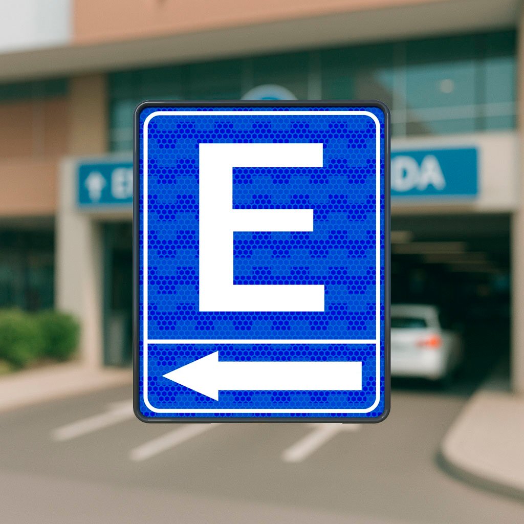 Señal azul con la letra “E” y flecha blanca que indica la dirección hacia una zona de estacionamiento público o privado