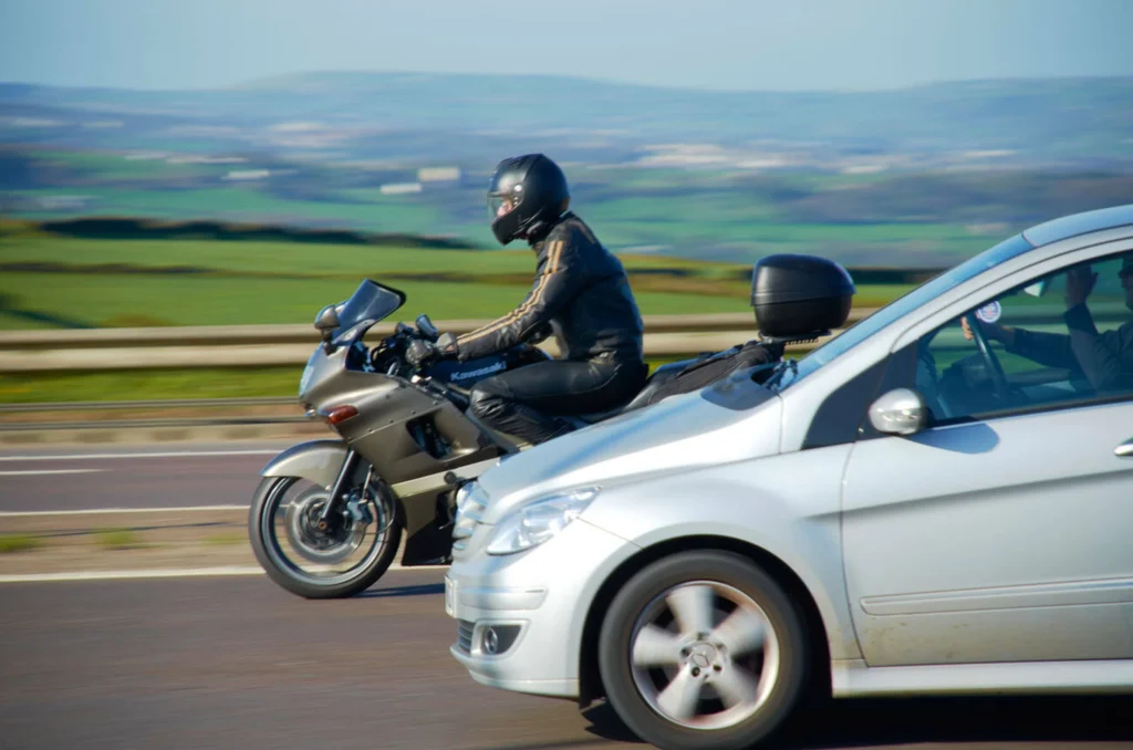 Automovilista y motociclista en exceso de velocidad, lo cual puede ocasionar choques entre motocicletas y automóviles