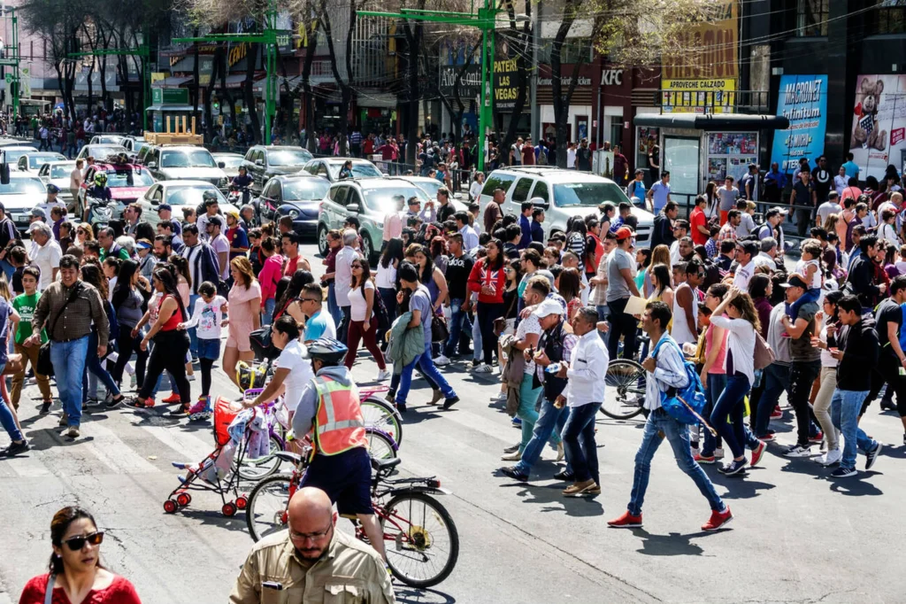 Cruce masivo de peatones en una avenida, ejemplo de organización vial en contextos de alta demanda.