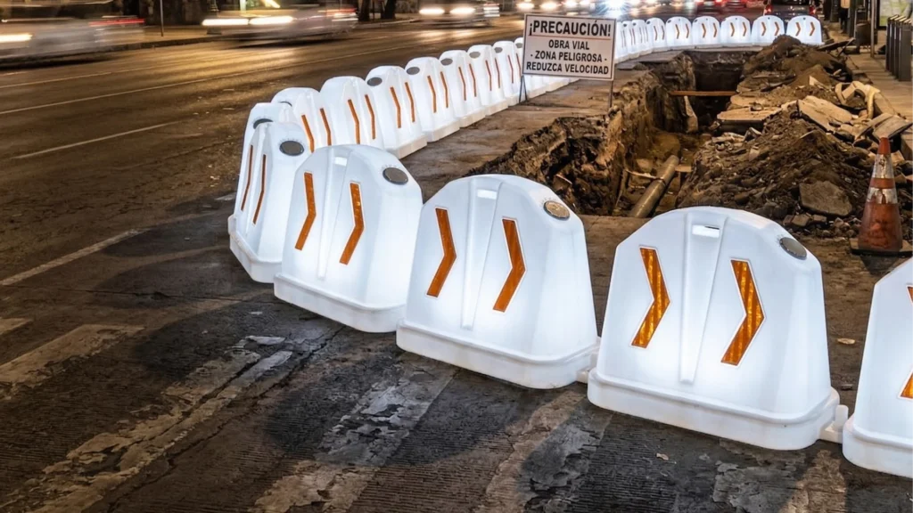 Barreras con luz integrada delimitando excavación en carretera con señalización visible